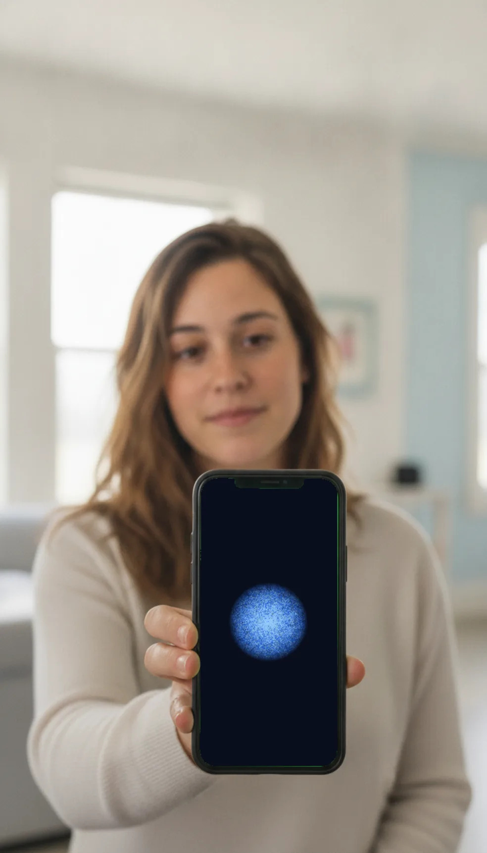 She stands in warm daylight beside her phone showing the coach orb.